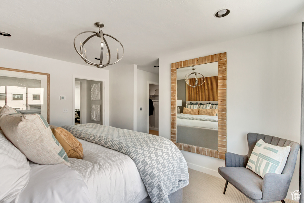 Bedroom featuring a spacious closet, a notable chandelier, carpet flooring, and a closet