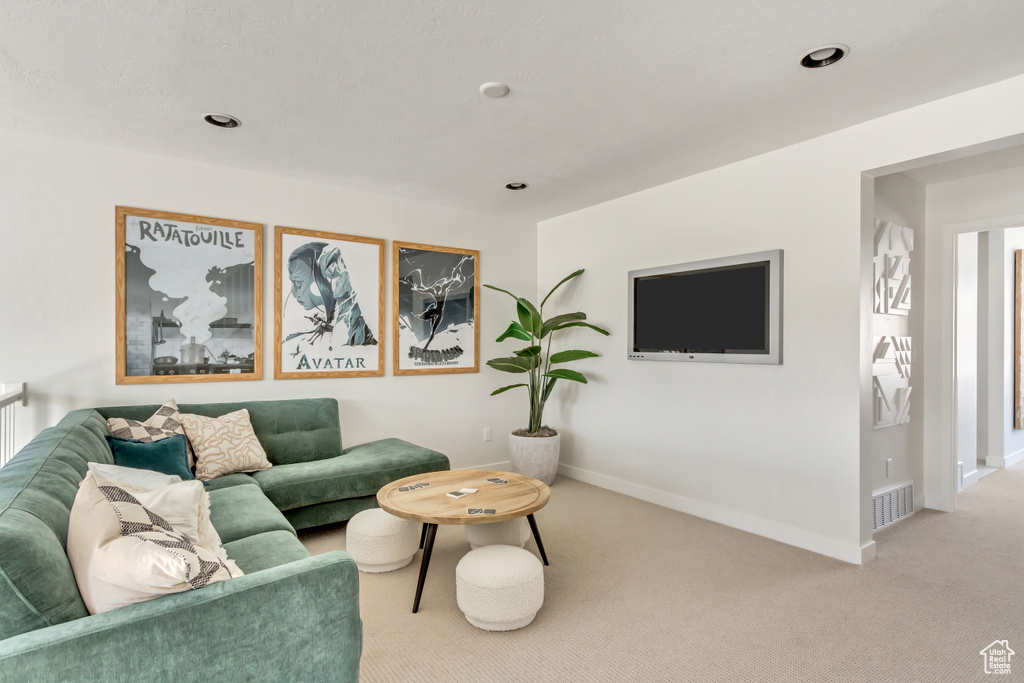 Carpeted living area with recessed lighting, visible vents, and baseboards