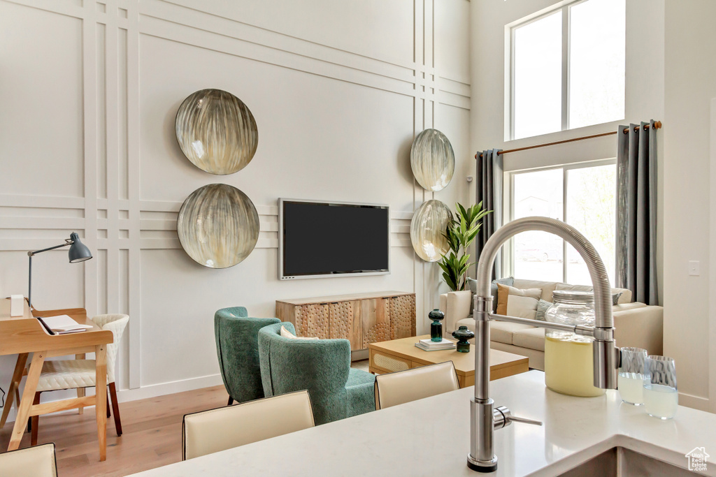 Living area featuring baseboards, wood finished floors, and a towering ceiling