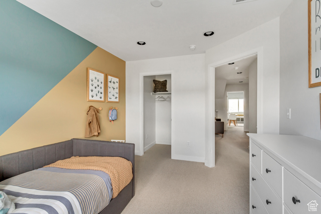 Bedroom featuring light colored carpet, baseboards, and a closet