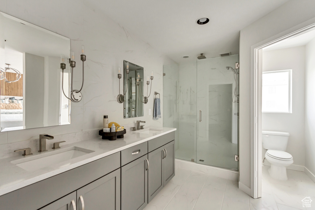 Bathroom featuring a sink, a marble finish shower, toilet, and marble finish floor