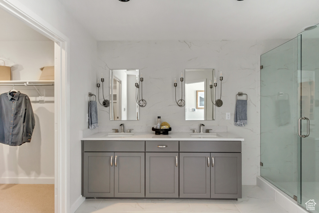 Full bathroom featuring a shower stall, marble finish floor, and a sink