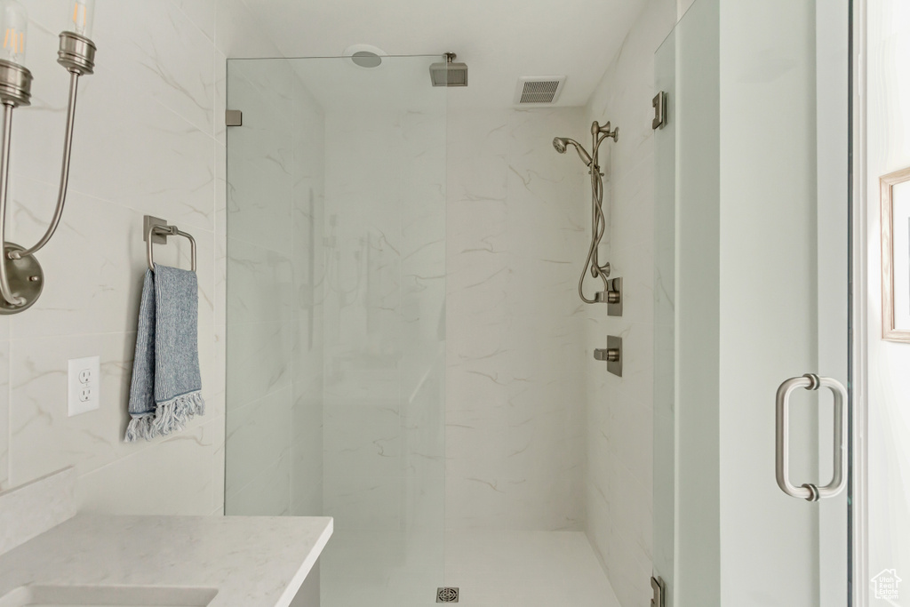 Full bathroom with vanity, visible vents, and a marble finish shower