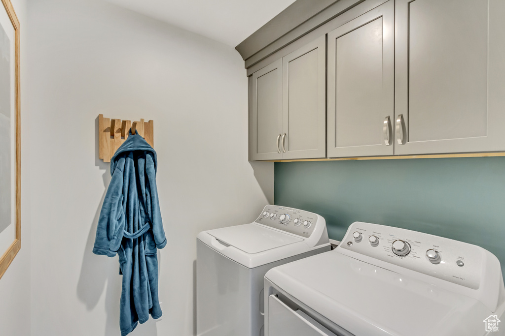 Laundry room featuring washer and clothes dryer and cabinet space