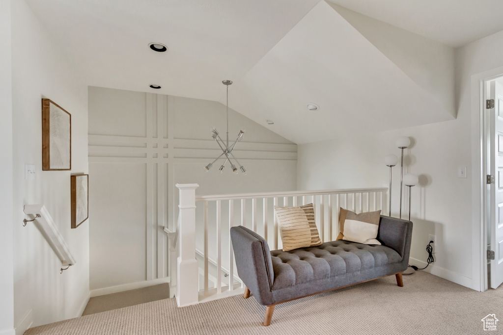 Living area featuring carpet, lofted ceiling, an upstairs landing, and baseboards