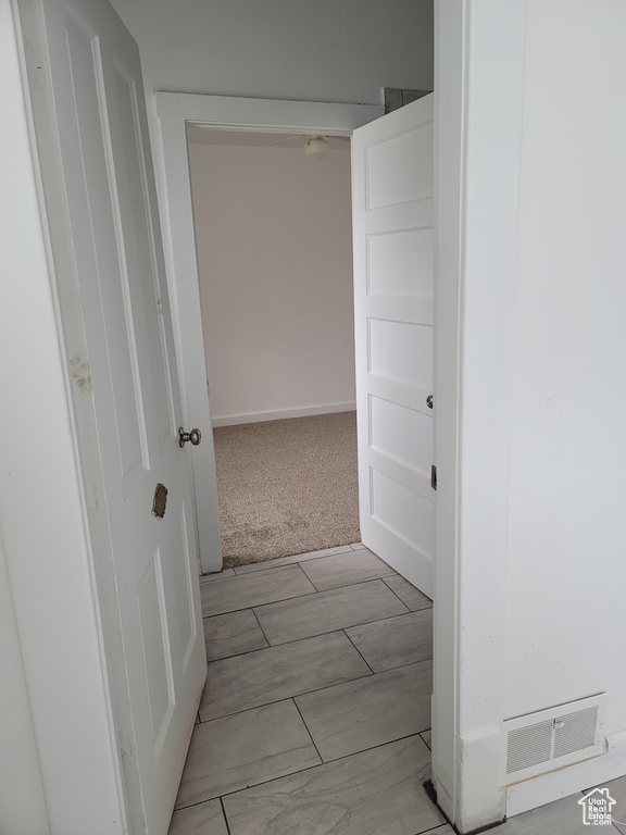 Hall featuring wood finish floors and light carpet