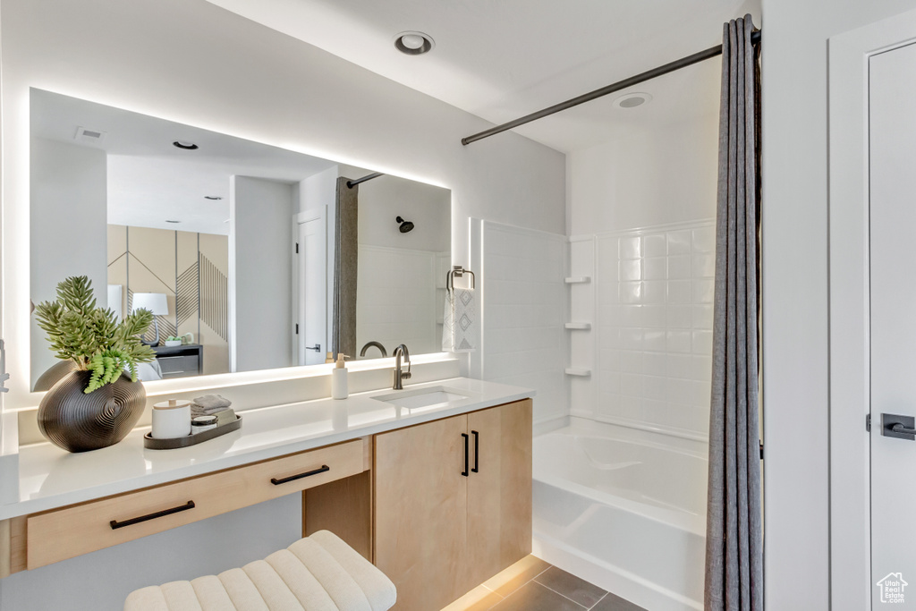 Full bathroom featuring tile patterned flooring, visible vents, vanity, and washtub / shower combination
