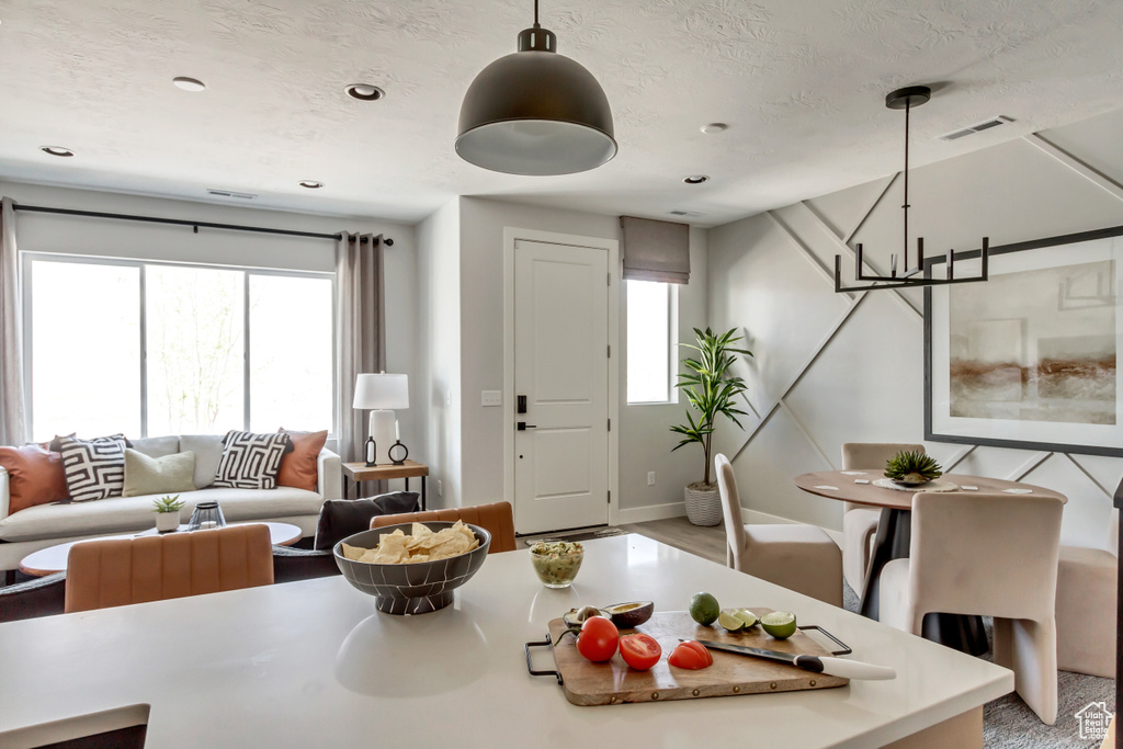 Living area with a wealth of natural light, visible vents, and a textured ceiling
