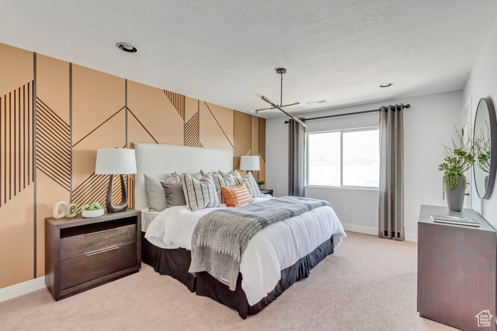 Bedroom with baseboards, light colored carpet, and a textured ceiling