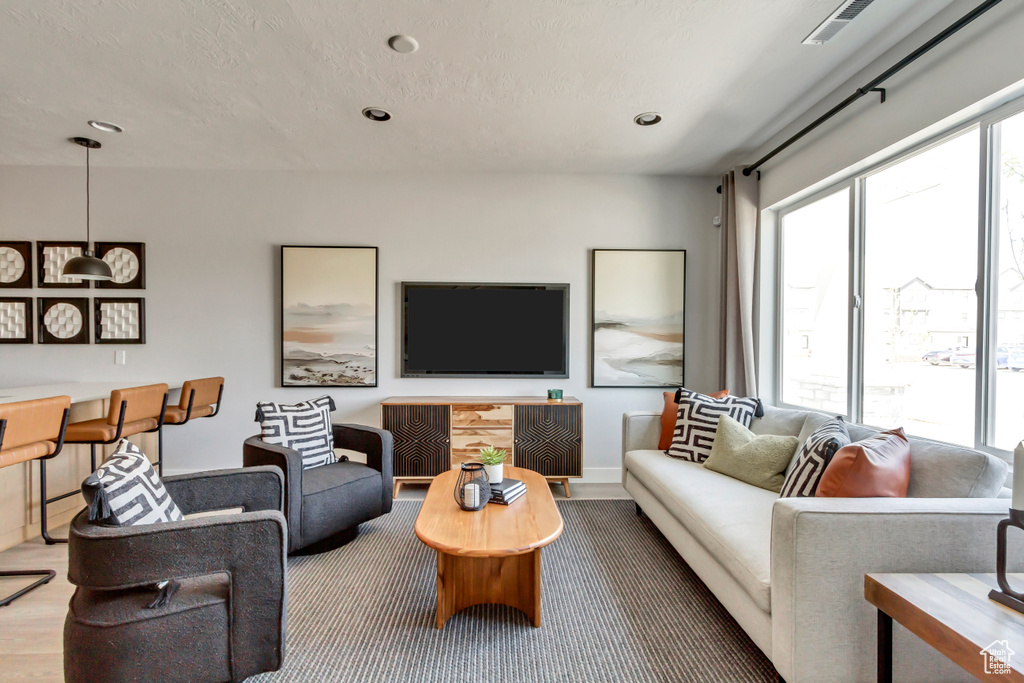 Living room with visible vents, recessed lighting, a textured ceiling, and baseboards