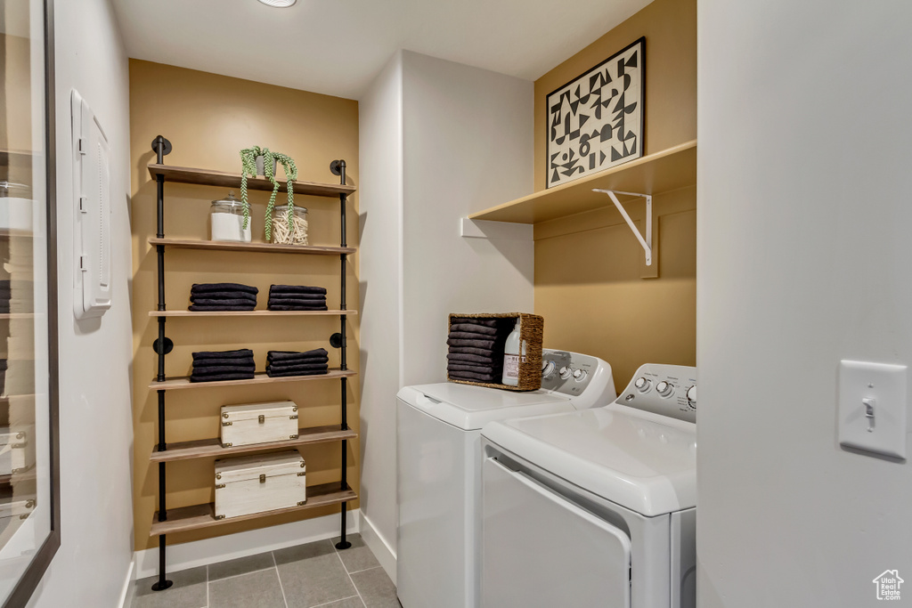 Laundry room with tile patterned flooring, baseboards, laundry area, and washer and clothes dryer