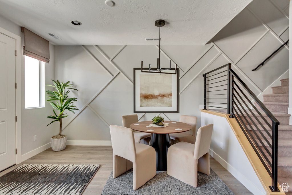 Dining space featuring stairway, visible vents, baseboards, and wood finished floors
