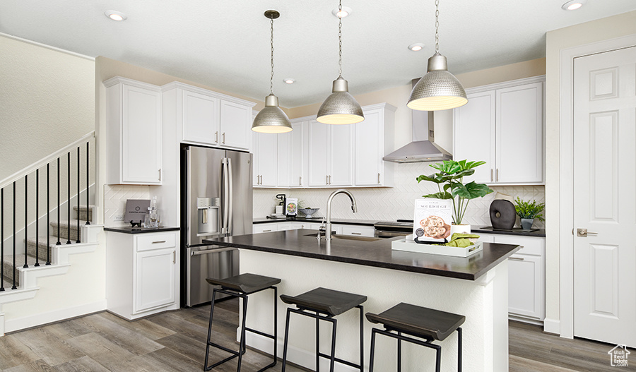 Kitchen featuring dark countertops, a breakfast bar area, appliances with stainless steel finishes, and a sink