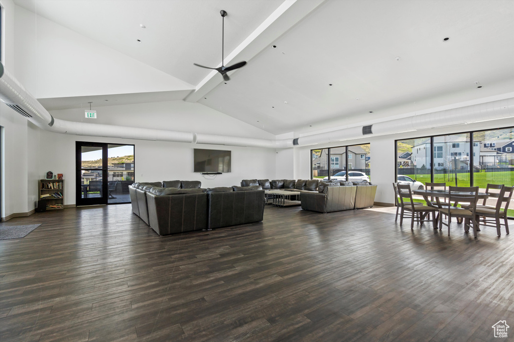 Living area with dark wood-style floors, beamed ceiling, and high vaulted ceiling