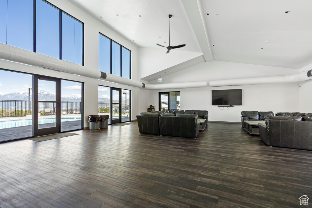 Living room featuring dark wood finished floors, high vaulted ceiling, and beamed ceiling