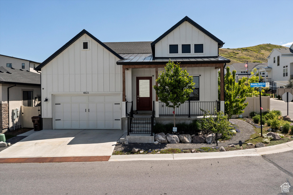Modern inspired farmhouse with a standing seam roof, a porch, and board and batten siding