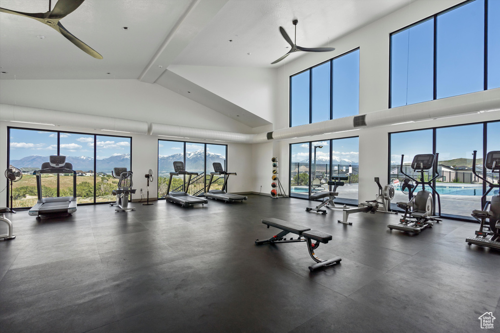 Exercise room with a ceiling fan and high vaulted ceiling