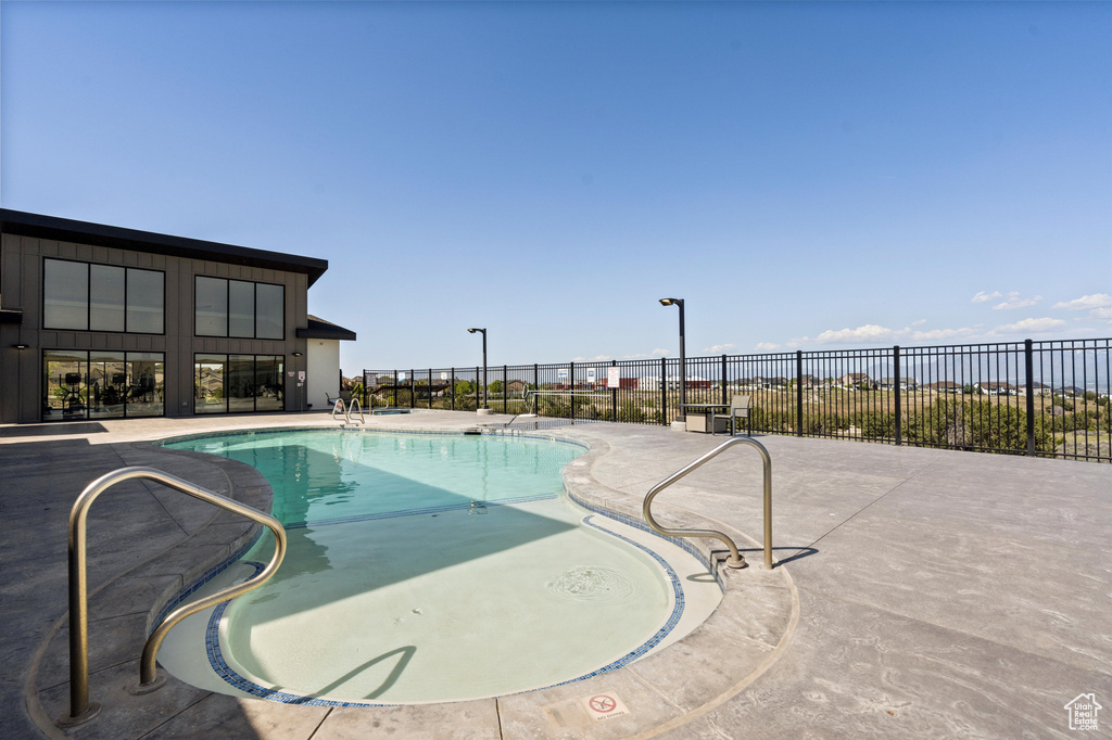 Community pool with fence and a patio area