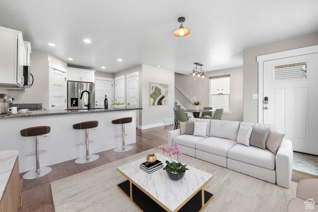 Living room featuring light wood-type flooring, recessed lighting, and baseboards