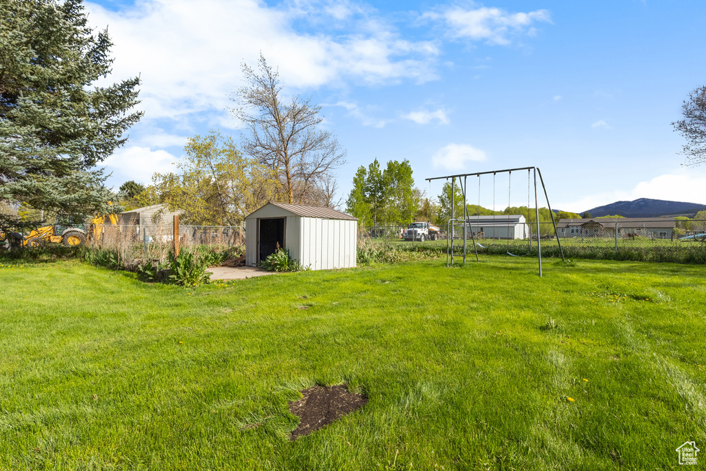 View of yard with fence and an outdoor structure