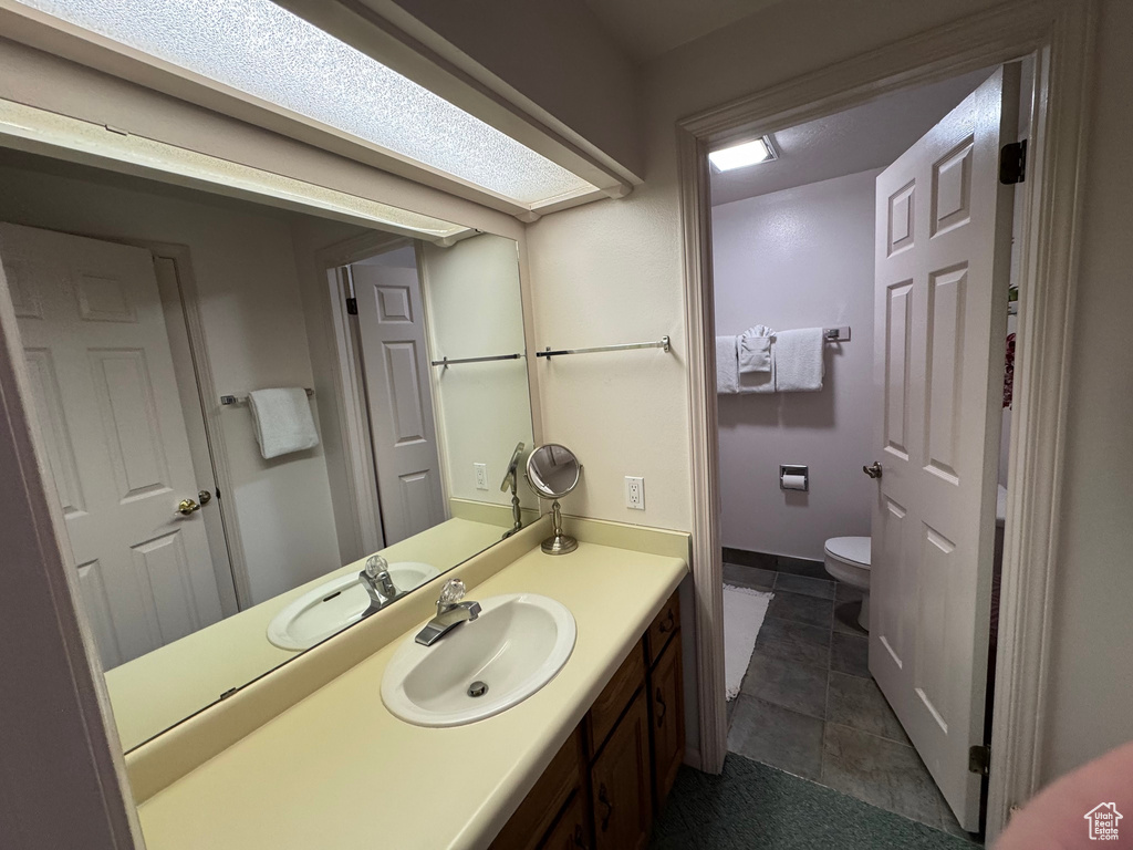 Bathroom featuring tile patterned flooring, toilet, and vanity
