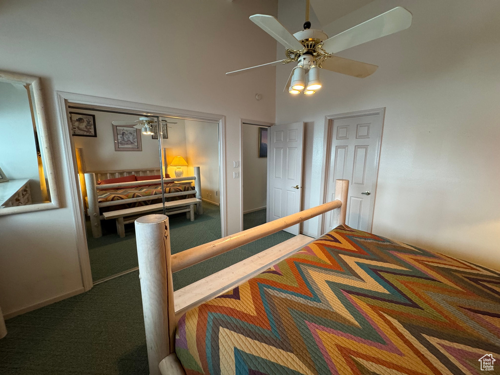Bedroom with a high ceiling, carpet flooring, and ceiling fan