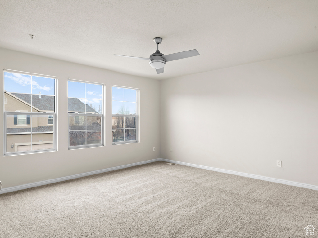 Unfurnished room with carpet, baseboards, and ceiling fan
