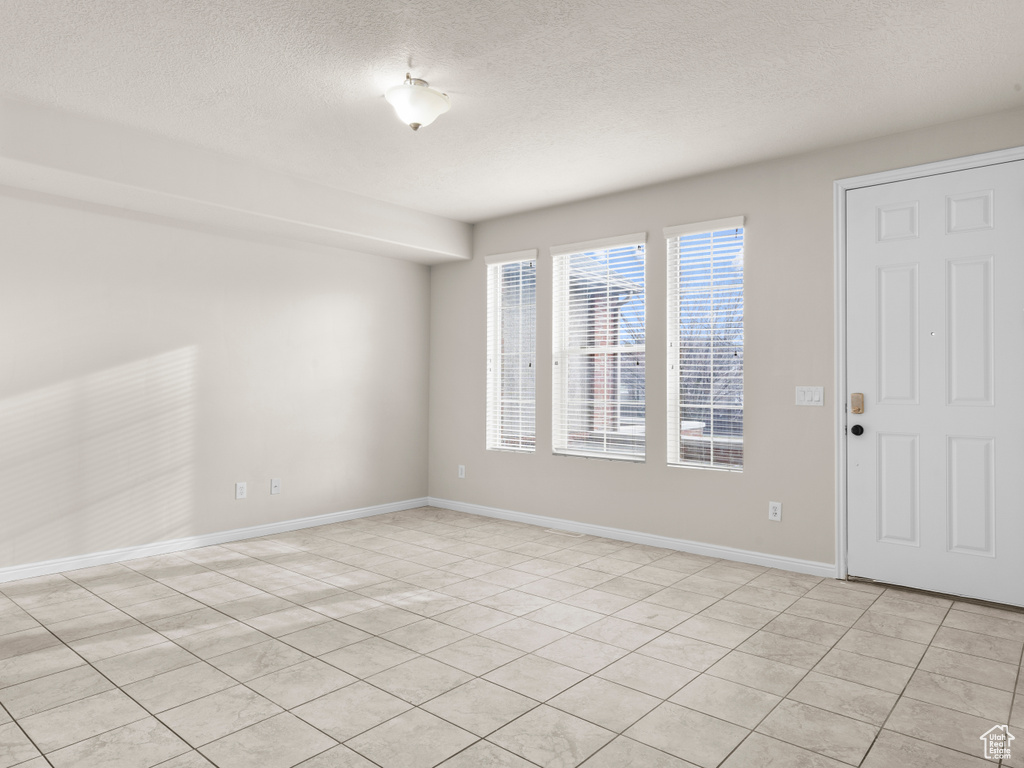 Unfurnished room featuring baseboards and a textured ceiling