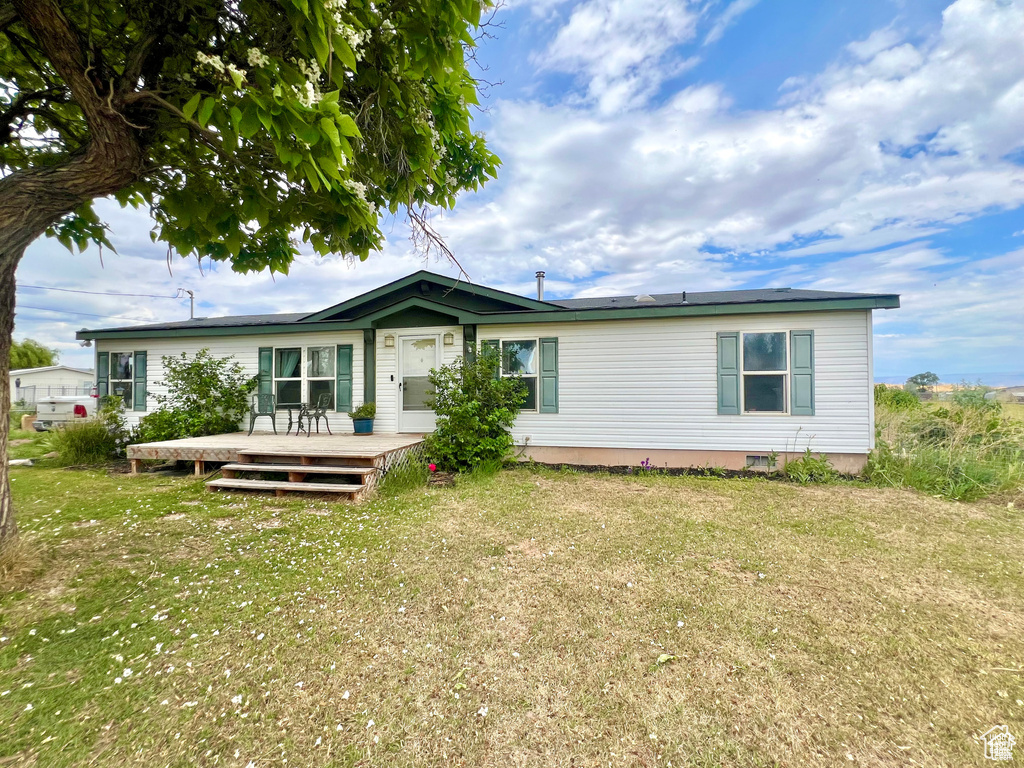 Rear view of house with a deck and a yard