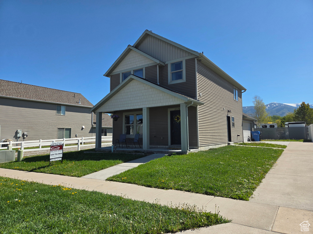 View of front of house with a porch, a mountain view, and a garage
