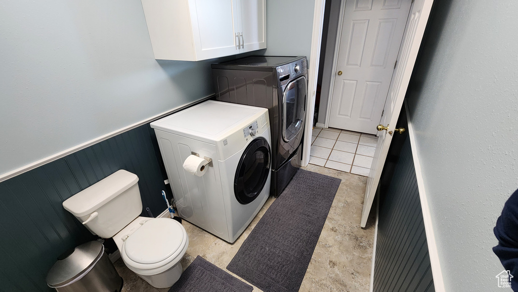 Laundry area featuring laundry area, a wainscoted wall, and separate washer and dryer