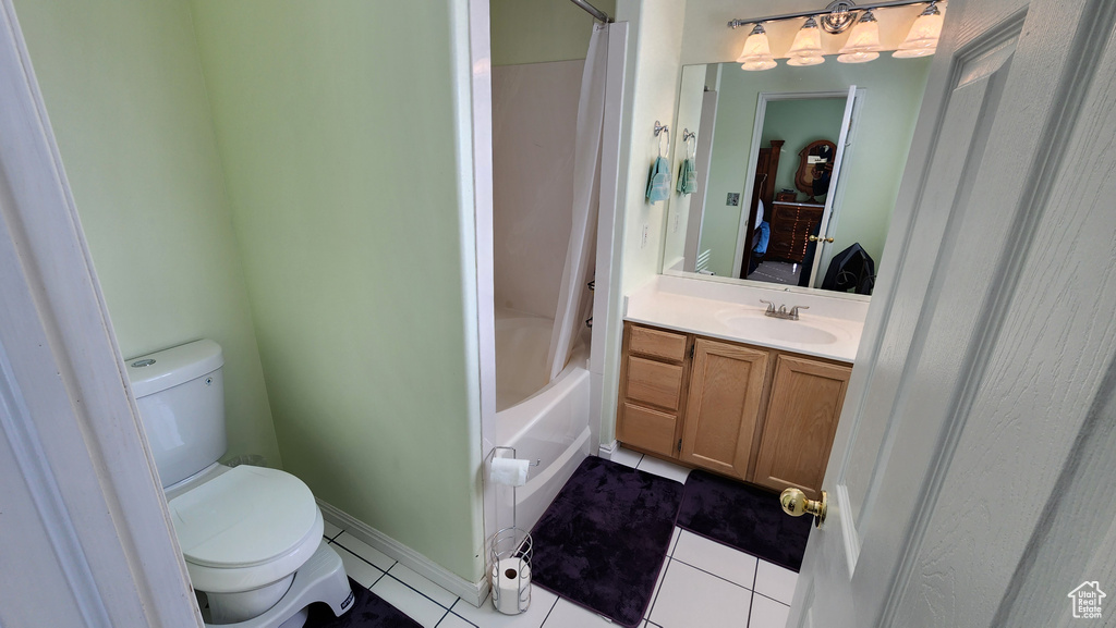 Full bathroom featuring tile patterned floors, toilet, vanity, and shower / bathtub combination with curtain