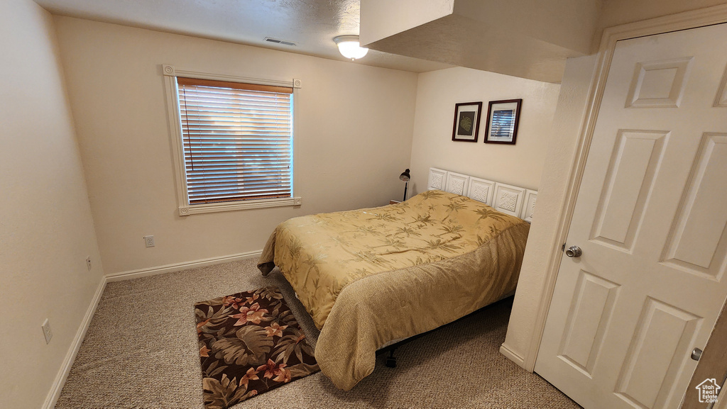 Carpeted bedroom featuring visible vents and baseboards