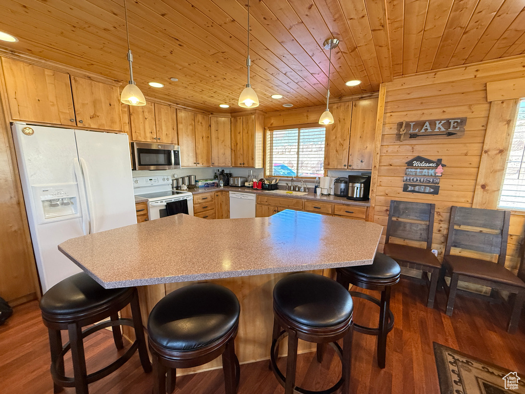 Kitchen with white appliances, wood ceiling, dark wood-type flooring, light countertops, and recessed lighting