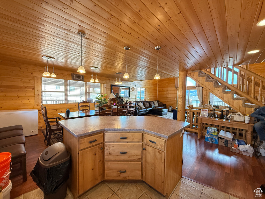 Kitchen featuring wooden ceiling, plenty of natural light, open floor plan, wood walls, and a kitchen island