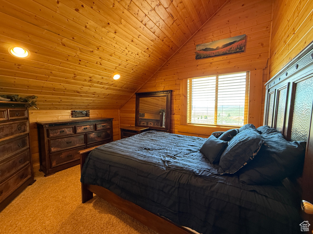 Bedroom featuring vaulted ceiling, wood walls, light colored carpet, and recessed lighting