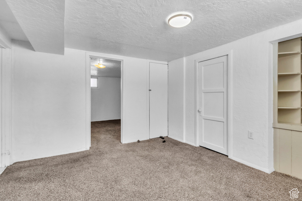Unfurnished bedroom featuring a textured ceiling and carpet