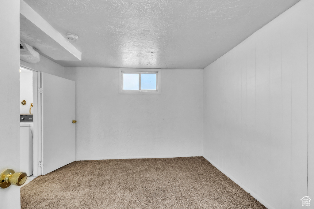 Below grade area with washer / clothes dryer, carpet flooring, and a textured ceiling