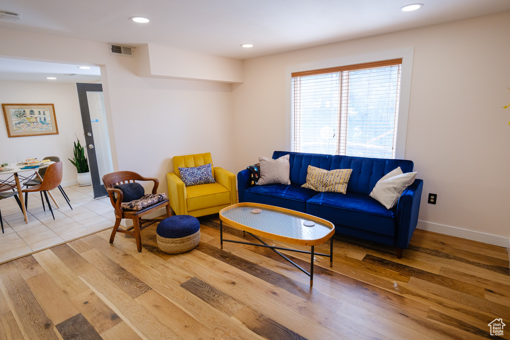 Living area featuring light wood-type flooring, visible vents, baseboards, and recessed lighting