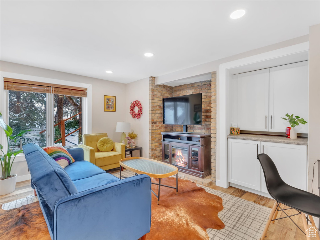 Living area with light wood finished floors, recessed lighting, and a fireplace