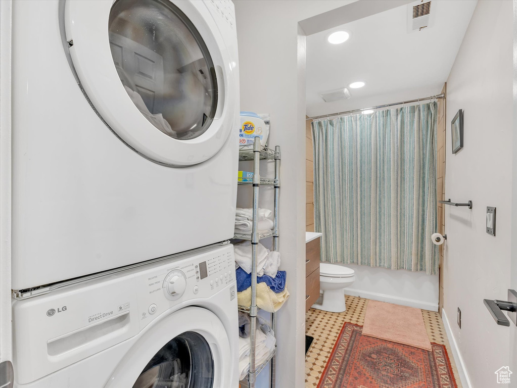 Laundry area featuring baseboards, visible vents, laundry area, recessed lighting, and stacked washer / drying machine