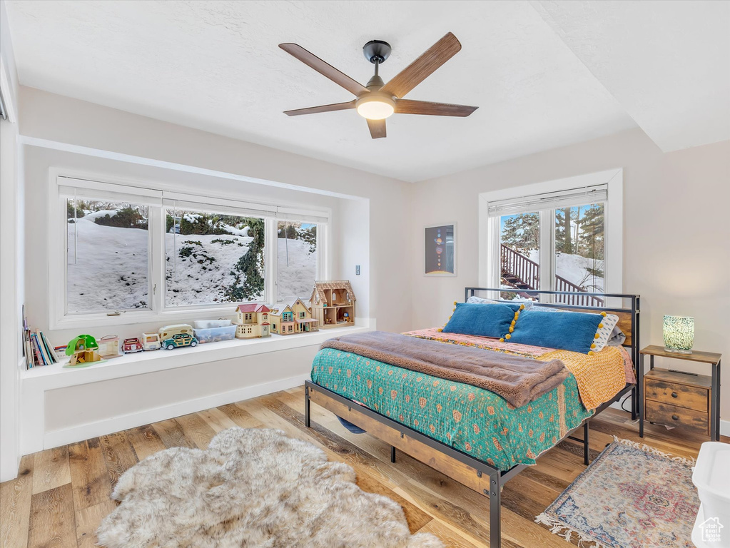 Bedroom featuring wood finished floors, baseboards, and ceiling fan