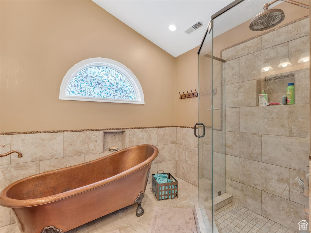 Full bath with tile patterned flooring, visible vents, a shower stall, a freestanding bath, and tile walls