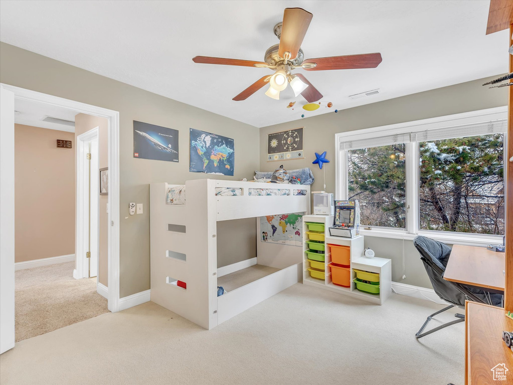 Carpeted bedroom with visible vents, baseboards, and ceiling fan