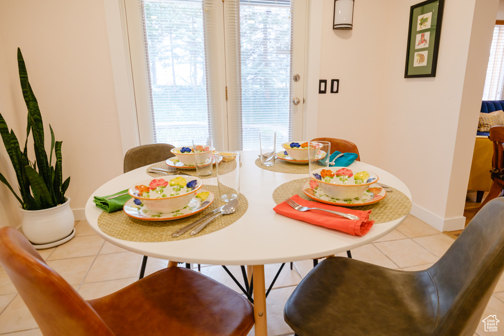 Dining room featuring baseboards, plenty of natural light, and tile patterned flooring
