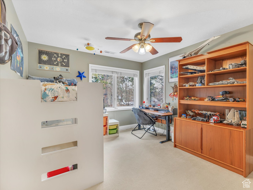Office space with visible vents, carpet flooring, and a ceiling fan