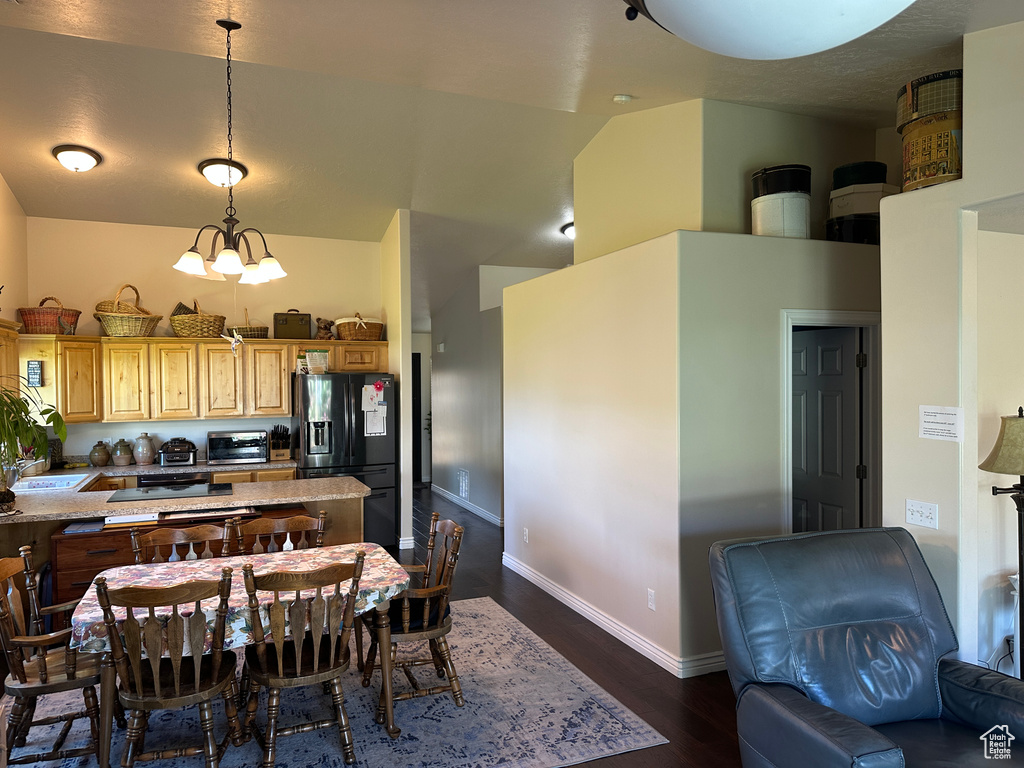 Kitchen with black refrigerator with ice dispenser, dark wood-type flooring, vaulted ceiling, a sink, and light brown cabinets