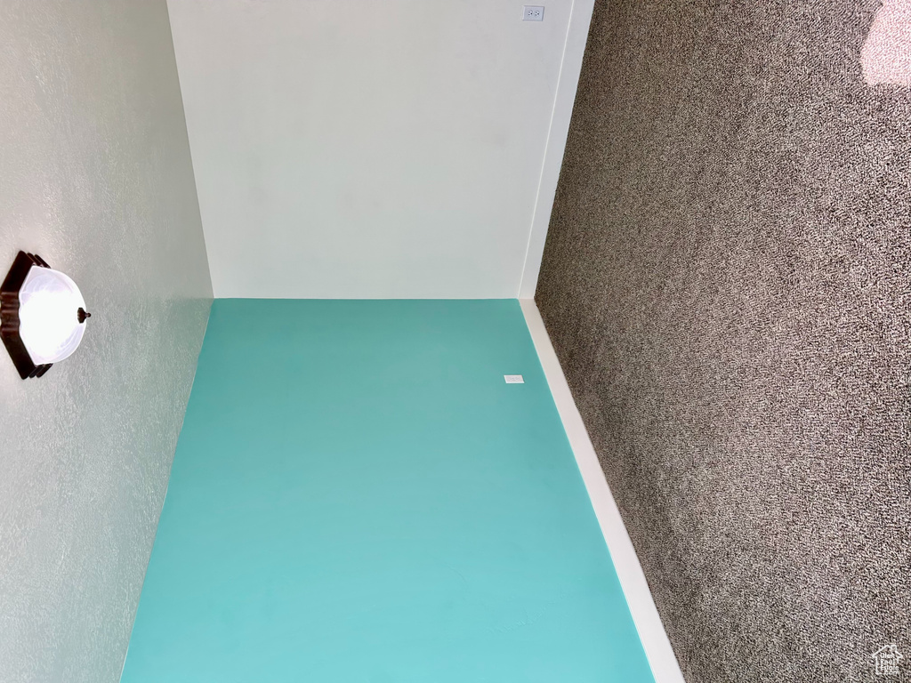 Spare room with baseboards, dark colored carpet, and a textured ceiling