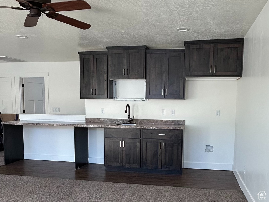 Kitchen with dark colored carpet, visible vents, baseboards, and light countertops