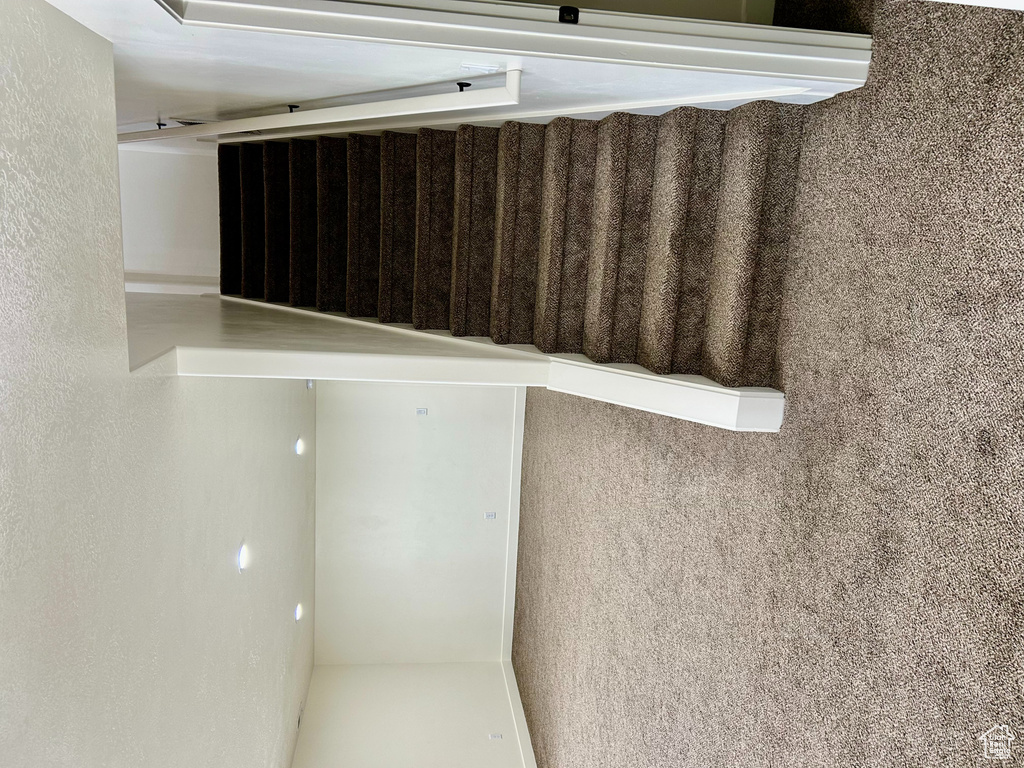 Staircase with recessed lighting, a textured ceiling, baseboards, and carpet floors